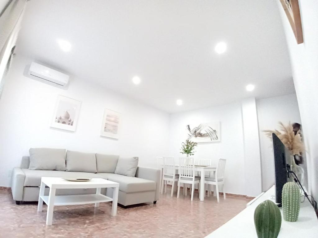 a white living room with a white couch and tables at Balcón del Cardenal in Baeza