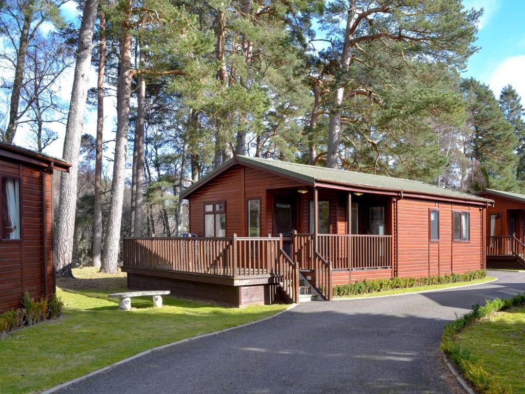 a small cabin with a porch and a walk way to it at Lodge D- Uk33090 in Dinnet