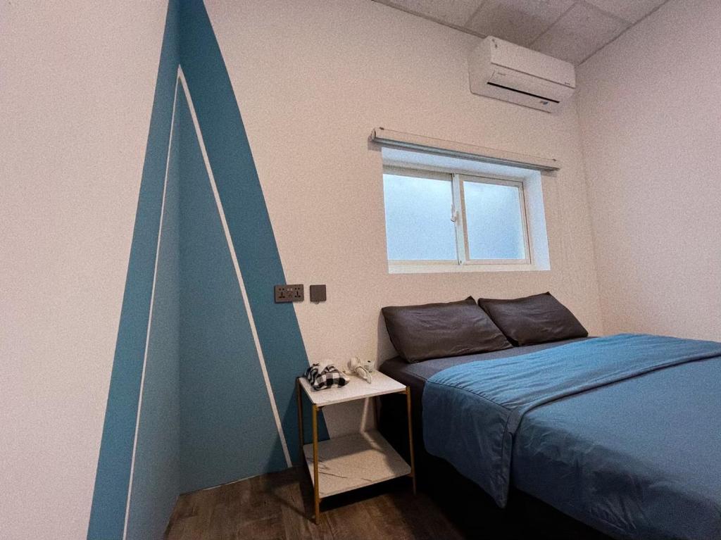 a bedroom with a bed and a blue accent wall at 私家潛水旅宿 in Green Island