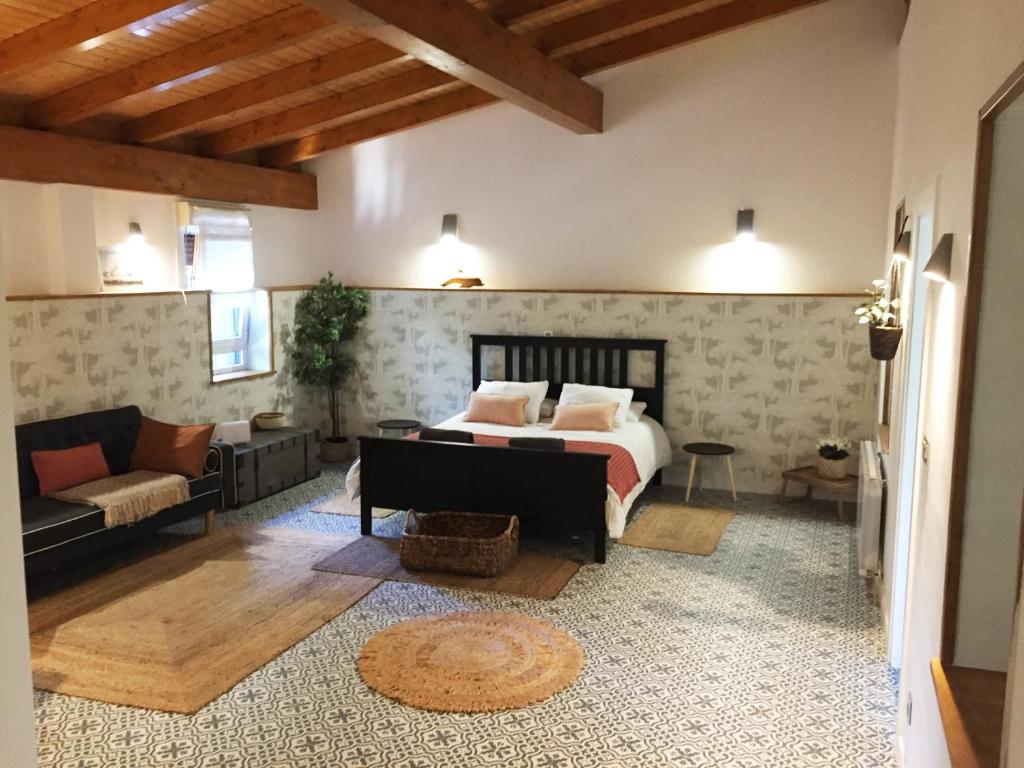 a bedroom with a bed and a couch in a room at Getxo Garden Houses - The Suite in Getxo