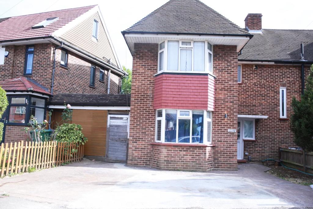 a brick house with a garage in front of it at Stunning 2-Bed Apartment in Harrow in Harrow