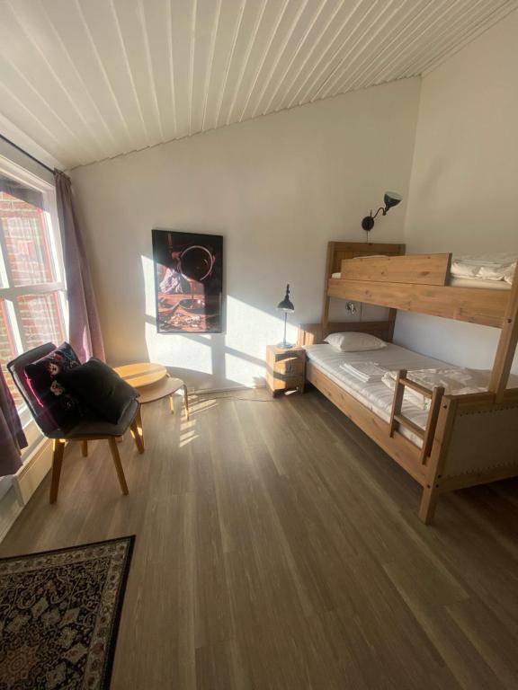 a bedroom with a bunk bed and a chair at Overnattingsrom Rudshøgda in Eriksrud