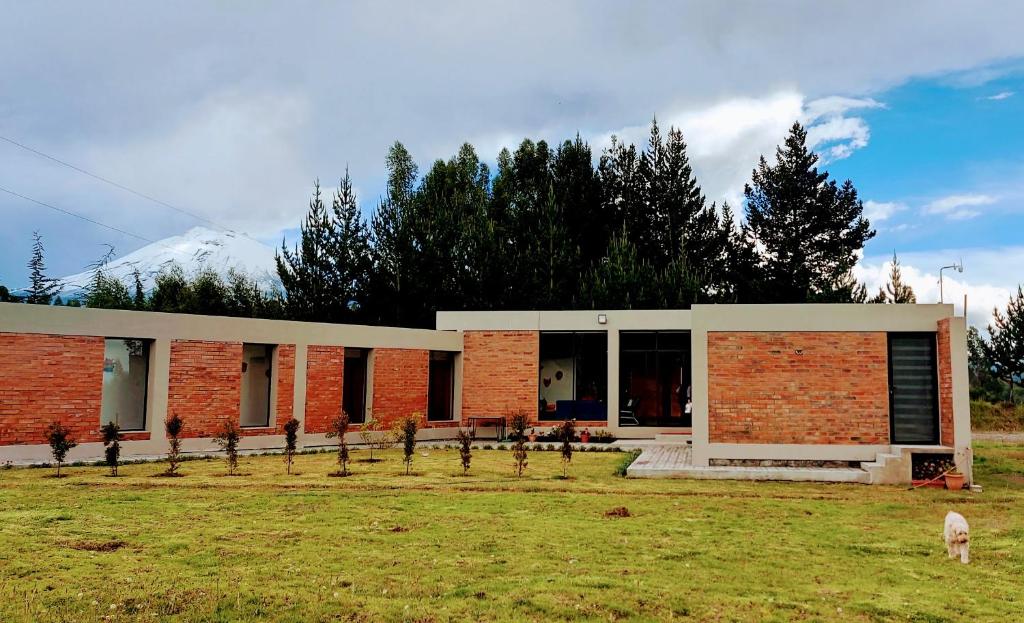 Un edificio de ladrillo con una valla delante. en El Chasqui Guest House, en Chasqui