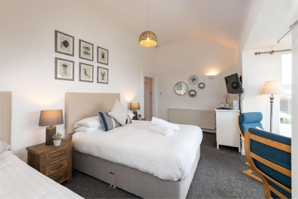 a bedroom with two beds and a television in it at Room 3 - Glan Neigr in Rhosneigr