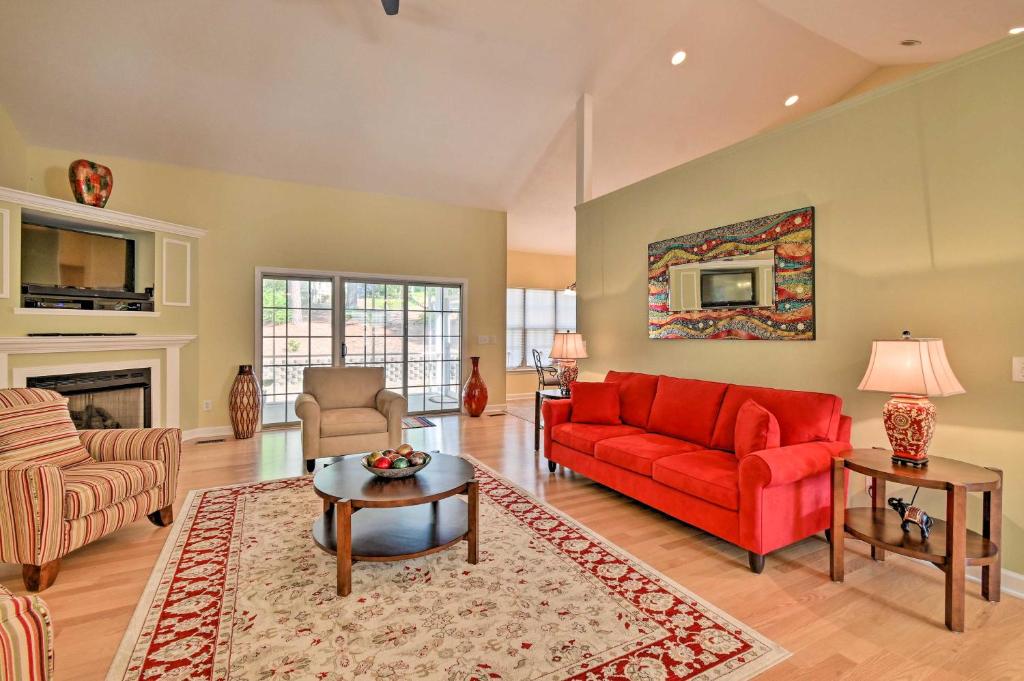 sala de estar con sofá rojo y chimenea en Sunny Home in Pinehurst Golf Course Community, en Pinehurst