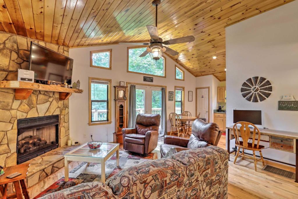 een woonkamer met een bank en een open haard bij Cozy Murphy Cabin Retreat with Deck and Fire Pit! in Salem