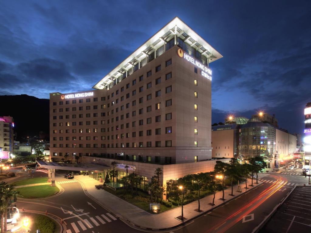 a tall building with a street at night at Nongshim Hotel in Busan