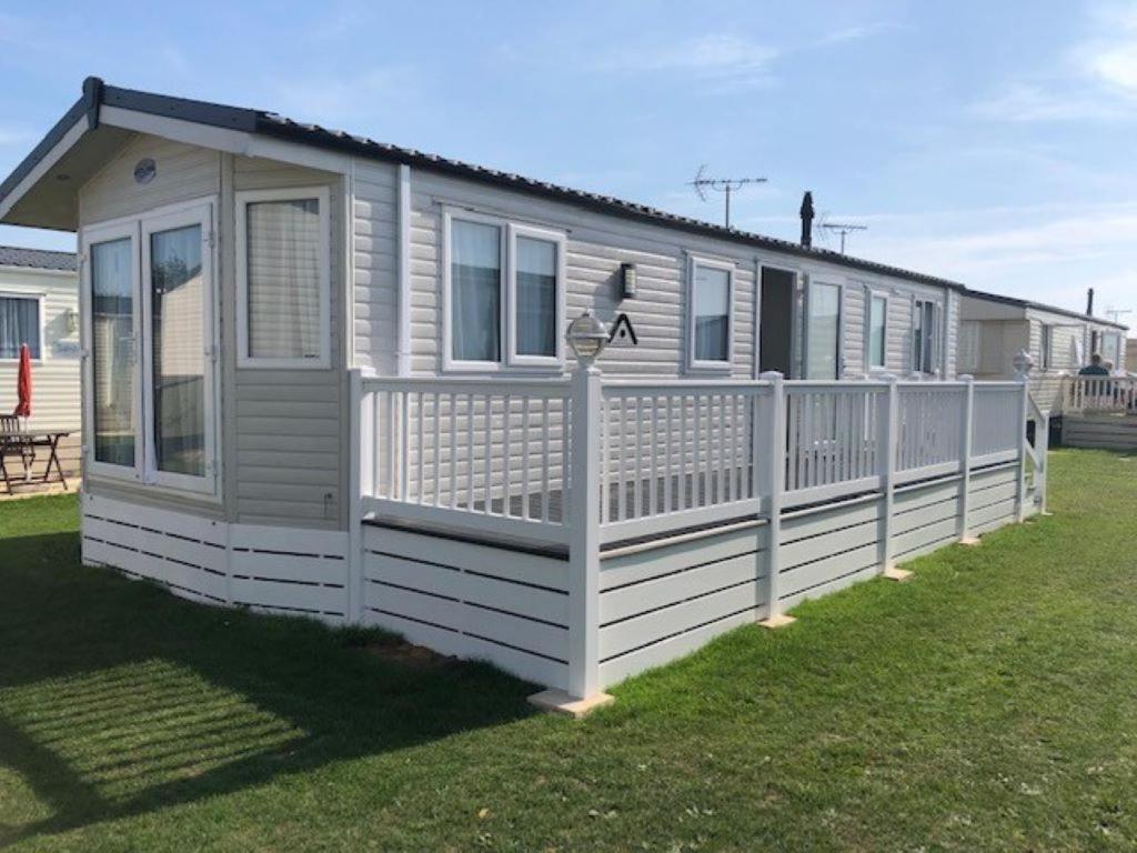 a white house with a fence in a yard at AMETHYST 25 in Whitstable