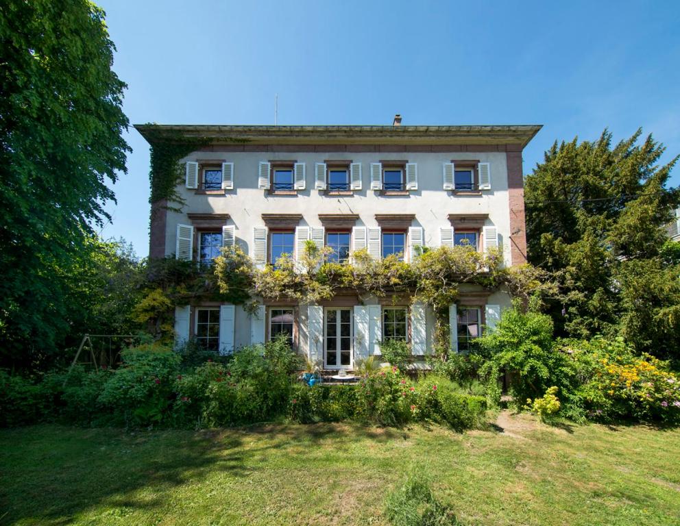 una casa vieja con flores en la parte delantera en Villa Grimm, en Sainte-Marie-aux-Mines