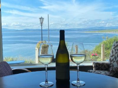 a bottle of wine and two glasses on a table at The Gaslight Inn Holiday Apartments & Licenced Restaurant Rossnowlagh in Rossnowlagh