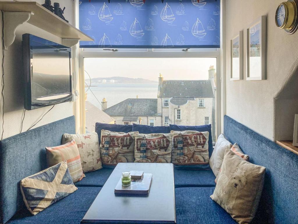a room with a couch and a table and a window at Coastal Views Millport in Millport