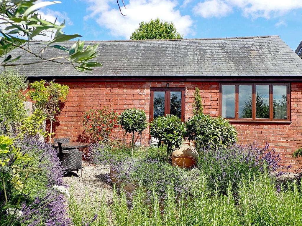 a brick house with a garden in front of it at Hop Kiln Barn in Staunton on Wye
