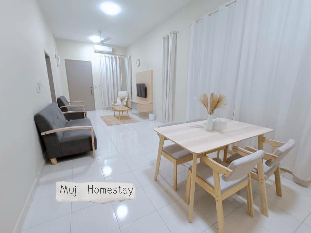 una sala de estar blanca con mesa y sillas en Muji Homestay, en Sungai Pelik