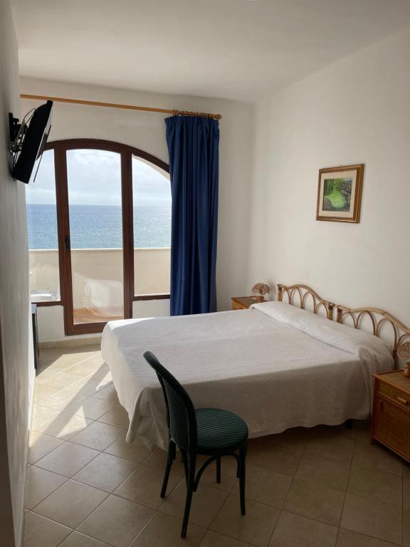 a bedroom with a bed and a view of the ocean at Hotel Miramare Garzia in Marinella di Selinunte