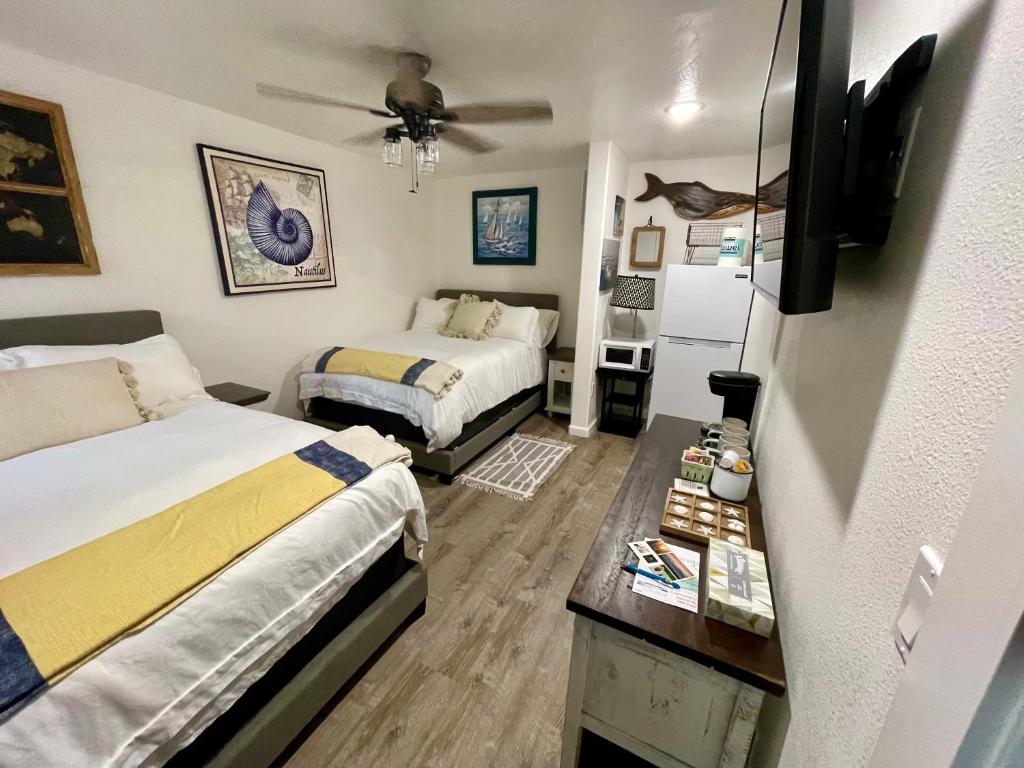 1 dormitorio con 2 camas y ventilador de techo en Seafarer Suites en Homer