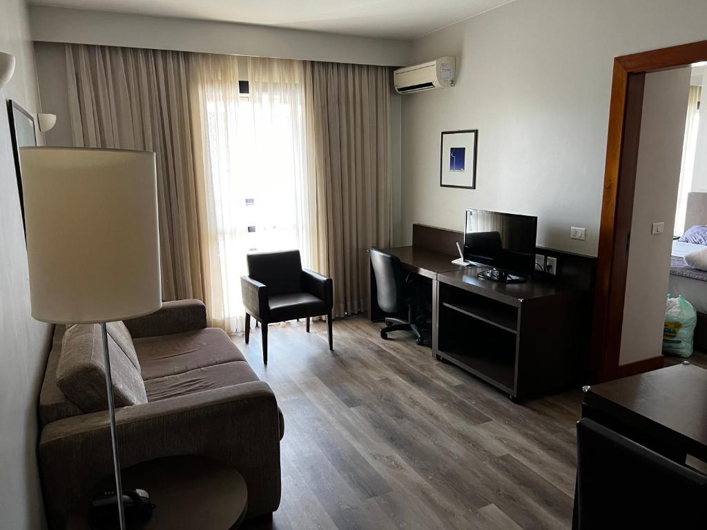 a hotel room with a bed and a desk at Hotel Bonaparte Flat Particular A in Brasilia
