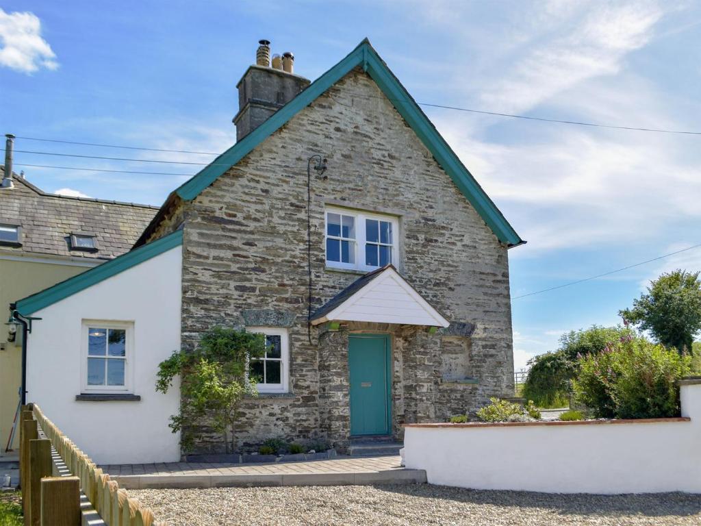 a stone cottage with a green door at Gamekeepers Cottage in Newchapel