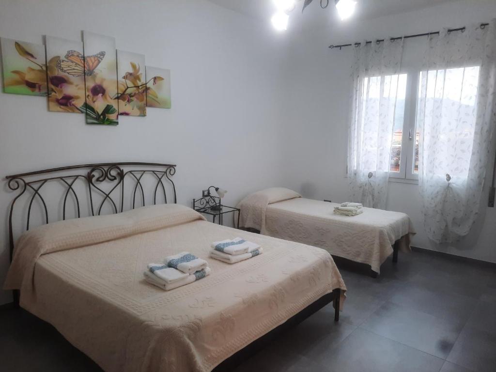 a bedroom with two beds with towels on them at CENTRAL ROOMS TORTOLI' in Tortolì