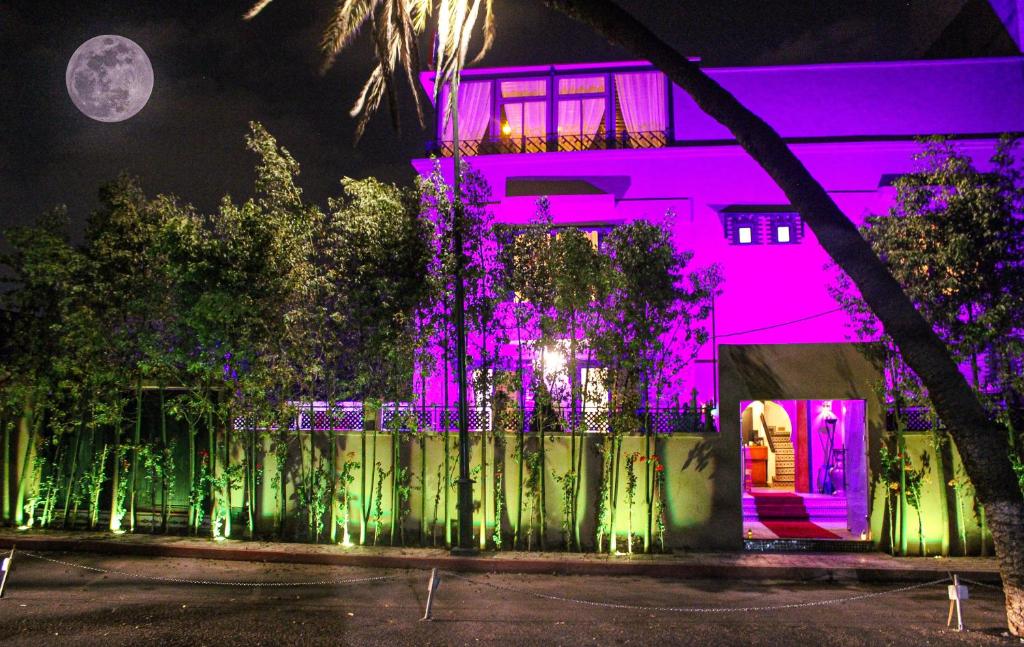a pink house with green and purple lights at Majorel Pearl Hotel-Riad-Restaurant Piscine&Spa in Marrakesh