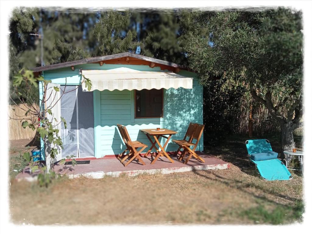 a table and chairs in front of a cabin at AGUA Cabaña con jardín y parking privado Chiclana in Chiclana de la Frontera