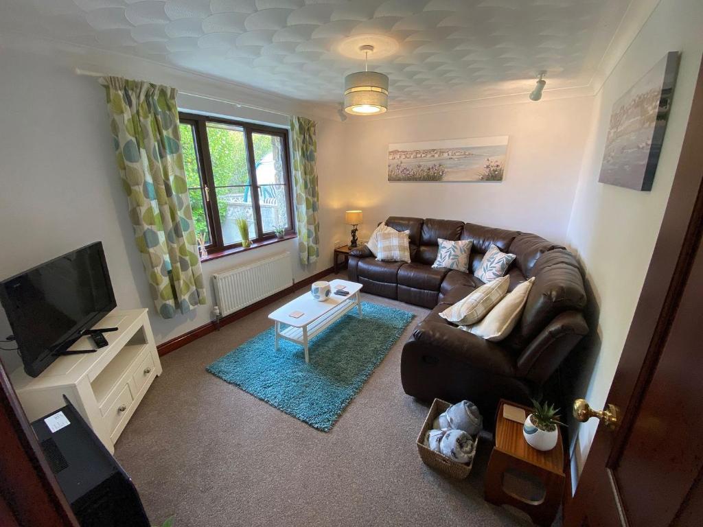 a living room with a couch and a tv at Highbury House in Camborne