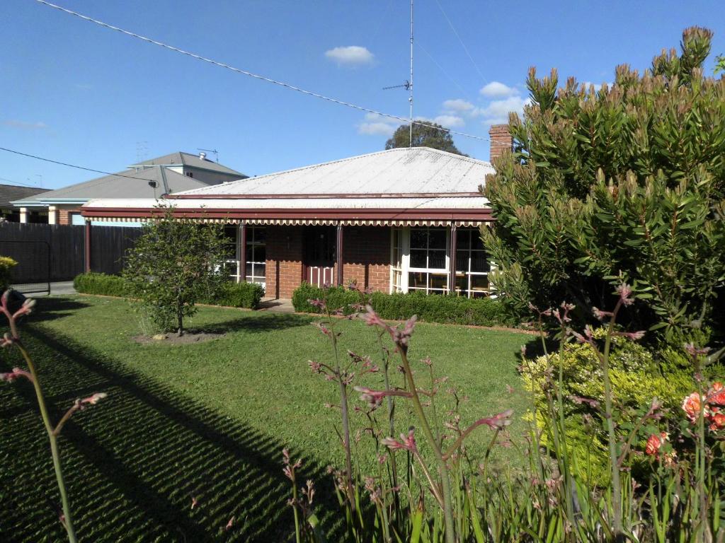 a house with a garden in front of it at Dunstans Guest House in Ballarat