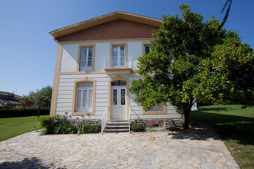 a white house with a tree in front of it at CASONA QUINTA HERMINIA in Gijón