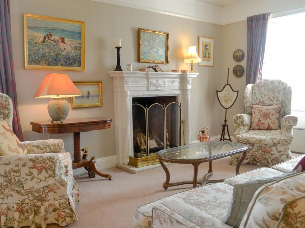 a living room with a fireplace and a table and chairs at Culpee House in Newton Stewart