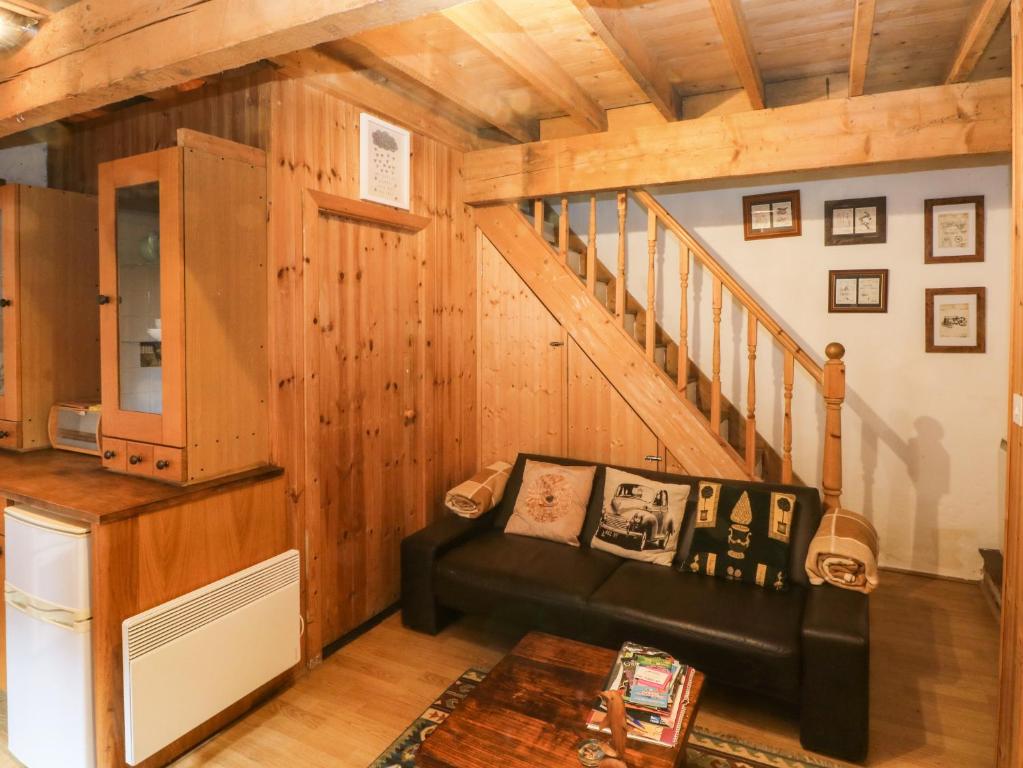a living room with a couch and a staircase at The Toolshed in Warrington