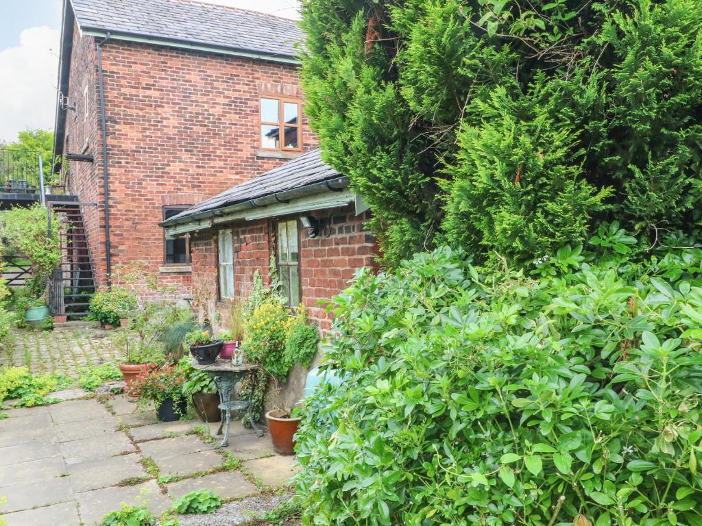 una casa de ladrillo con un jardín delante de ella en The Toolshed, en Warrington