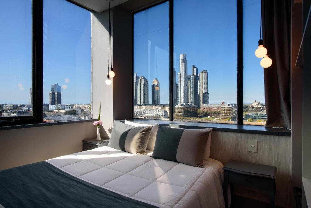 sypialnia z dużym oknem z widokiem na miasto w obiekcie Believe Madero Hotel w BuenosAires