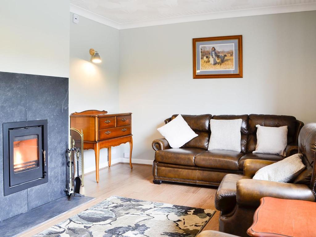 a living room with a couch and a fireplace at Pant Yr Awel in Llanycrwys