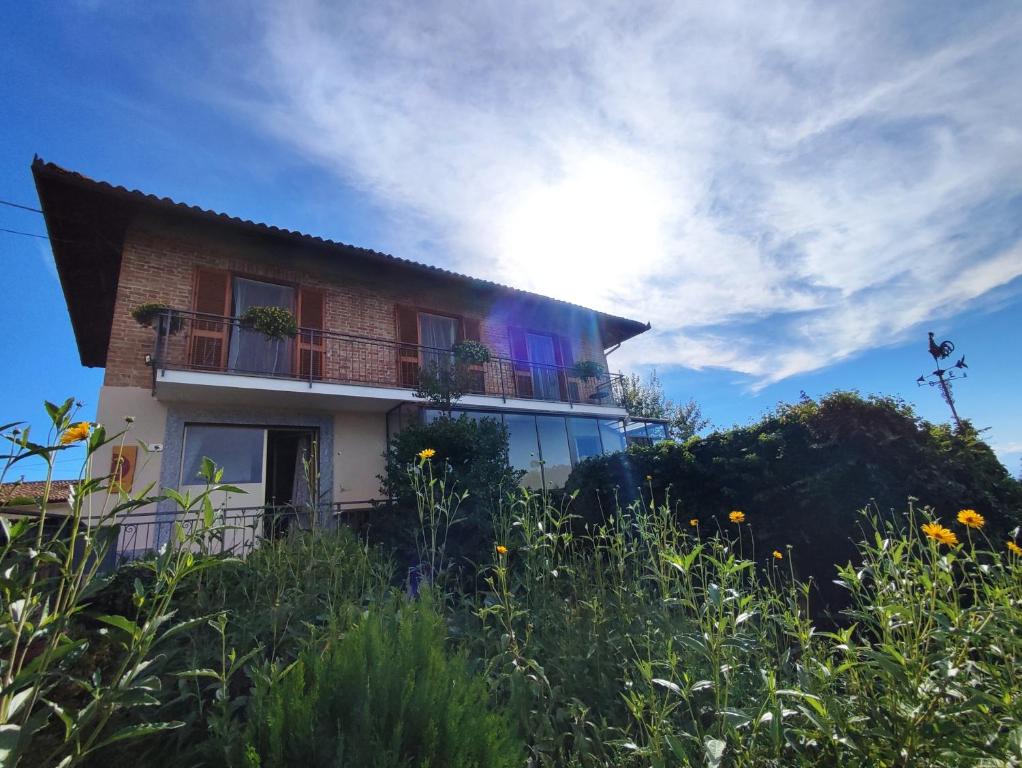 une maison sur une colline avec le soleil dans le ciel dans l'établissement Ca di me, à La Morra