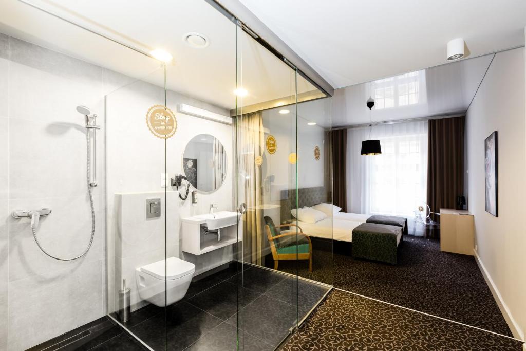 a bathroom with a shower and a toilet and a sink at Sleep in Hostel & Apartments Stare Miasto in Poznań