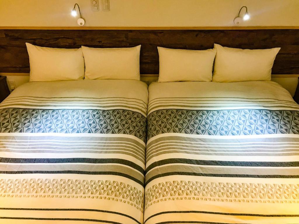 a bedroom with a bed with a large bedspread at Niruyakanaya BISE - Vacation STAY 44389v in Bise