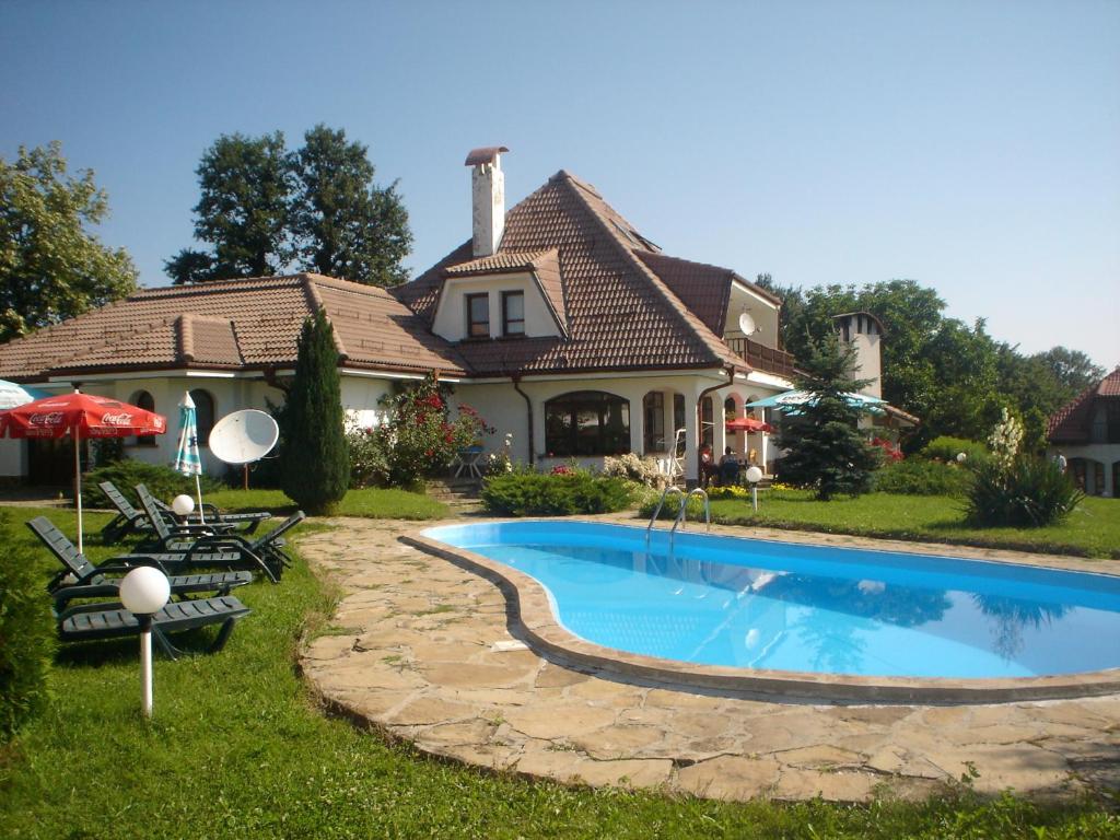 a house with a swimming pool in front of a house at Complex Roden Kray in Vlaychovtsi