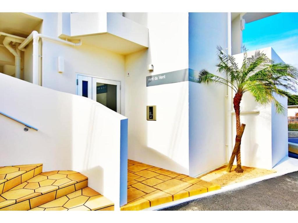 a palm tree in front of a building at Vent du Vent - Vacation STAY 83347v in Urasoe