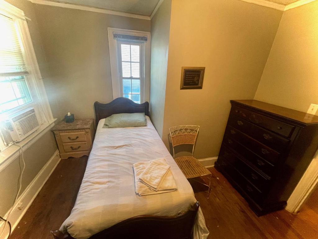 Dormitorio pequeño con cama y vestidor en Best Rooming Houses in Rocky Mount NC., en Rocky Mount