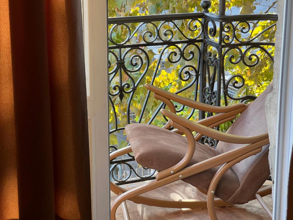 una sedia a dondolo su un balcone con cancello di Lola Apartments a Tbilisi City