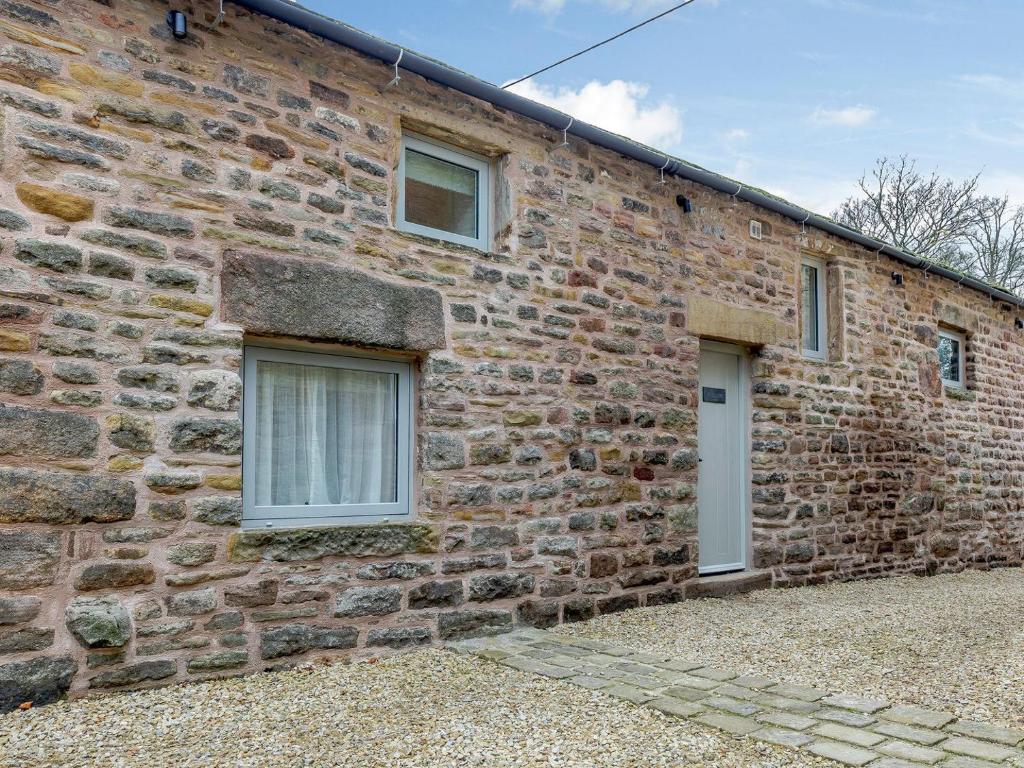 a brick building with two windows and a door at Willow Cottage At Naze Farm-uk32760 in Chinley