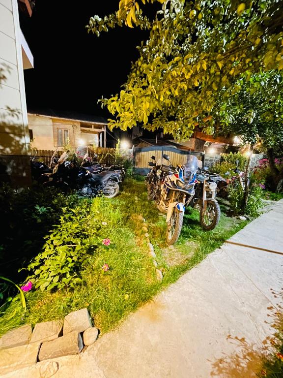 two motorcycles parked in the yard of a house at night at Hotel Elite House in Mestia
