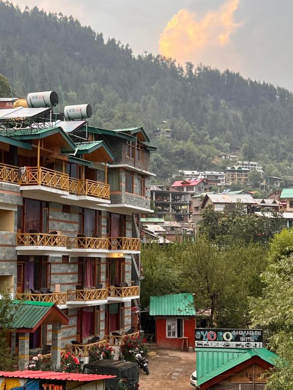 eine Gruppe von Gebäuden vor einem Berg in der Unterkunft YOLO Backpackers MAX - Manali in Manali