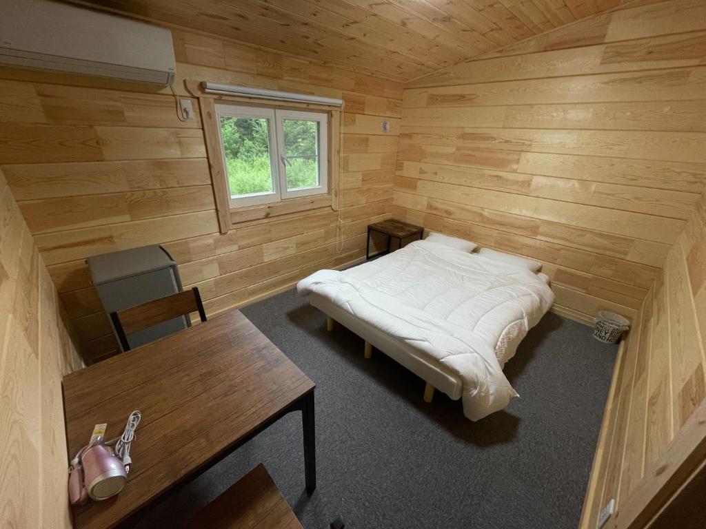 Habitación con cama y escritorio en una habitación de madera. en Biwako Hills Resort - Vacation STAY 47924v en Takashima