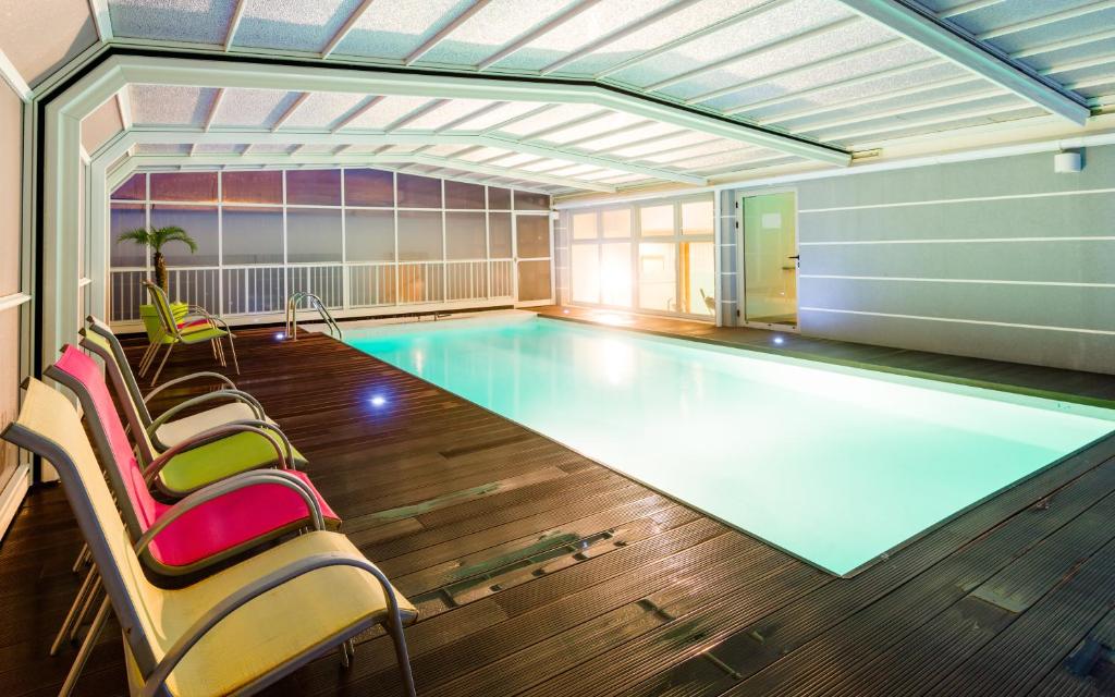 einen großen Pool mit Stühlen in einem Zimmer in der Unterkunft Lagrange Apart'Hotel l’Escale Marine in La Rochelle