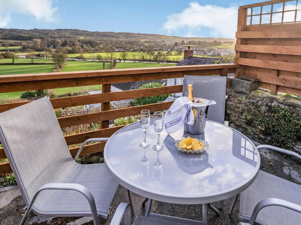 a white table with wine glasses on a balcony at Number 4 in Llandeilo