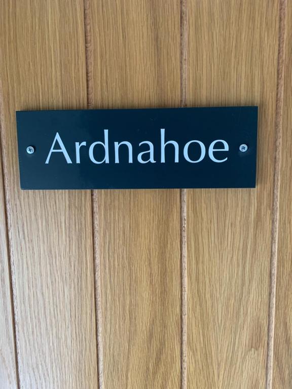 a blue sign on a wooden door with the word antidenride at Lochindaal Hotel in Port Charlotte