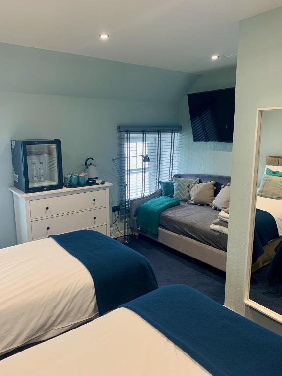 a bedroom with two beds and a television in it at Lochindaal Hotel in Port Charlotte