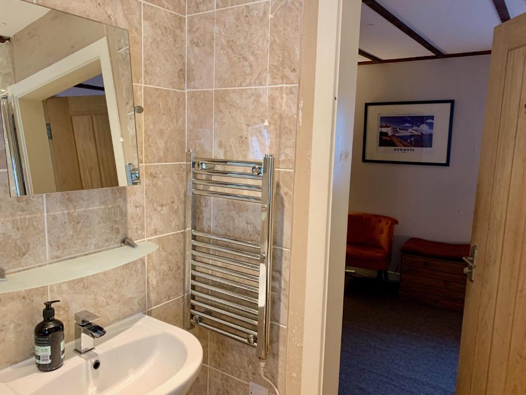 a bathroom with a sink and a mirror at Lochindaal Hotel in Port Charlotte