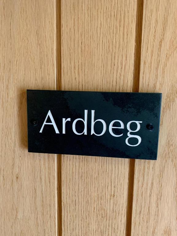 a sign on a wooden door with the word antles at Lochindaal Hotel in Port Charlotte