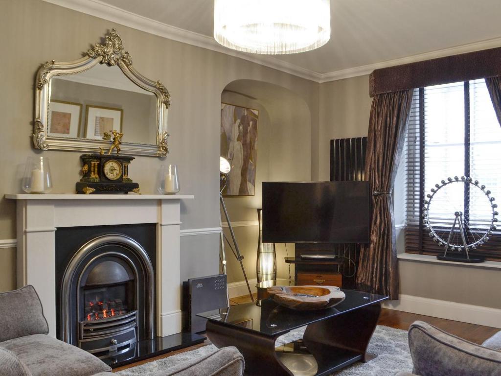 a living room with a fireplace and a tv at The Apartment in Brecon